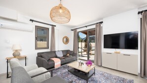 A modern living room with a grey sofa, a coffee table, and a TV. - Villa Lidya in Dalyan (Ortaca)