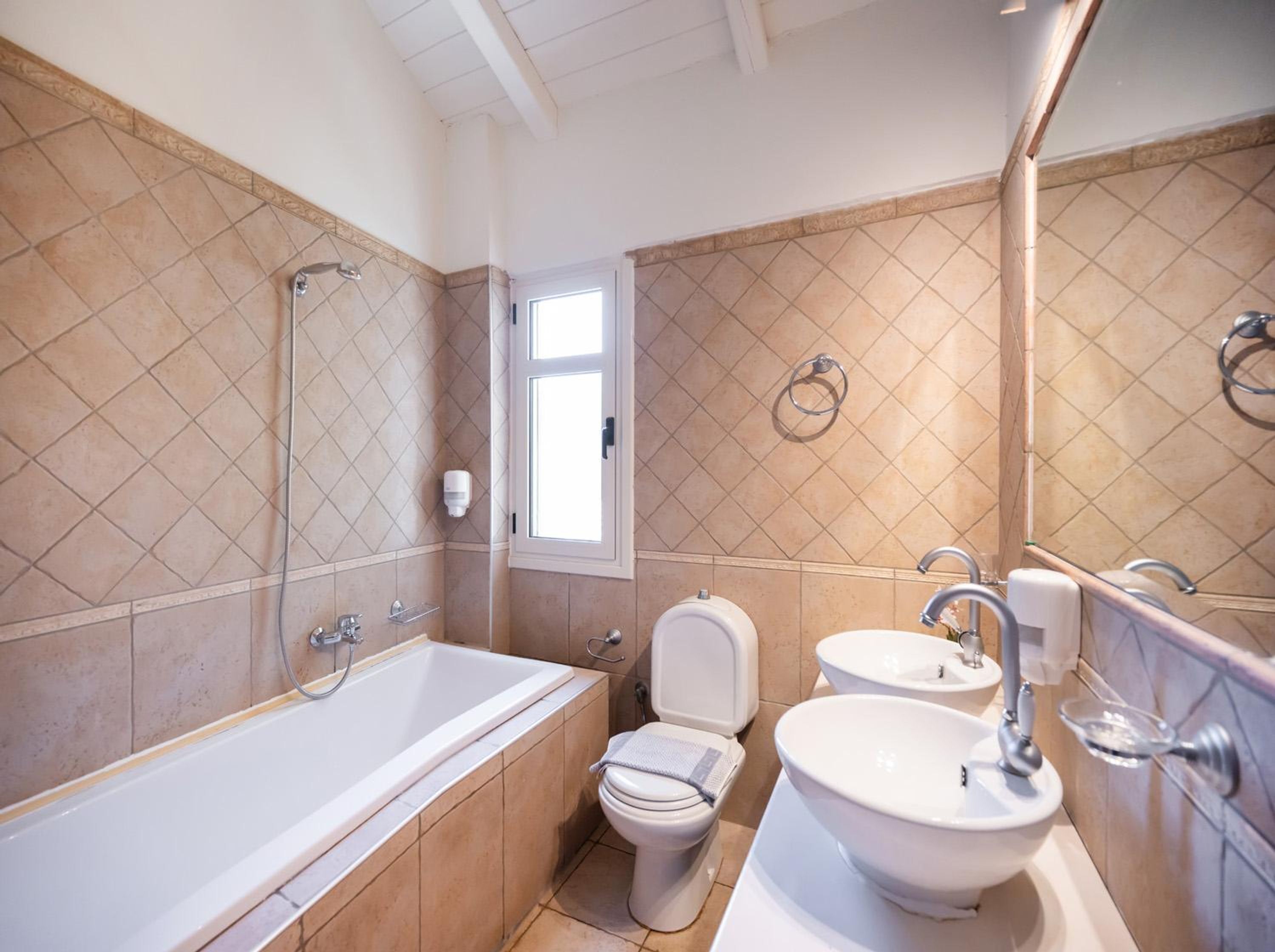 Un baño con bañera, inodoro y lavamanos, todo con accesorios modernos.