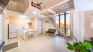 Eine moderne Wohnung mit Küche, Essbereich, Treppe und Balkon.