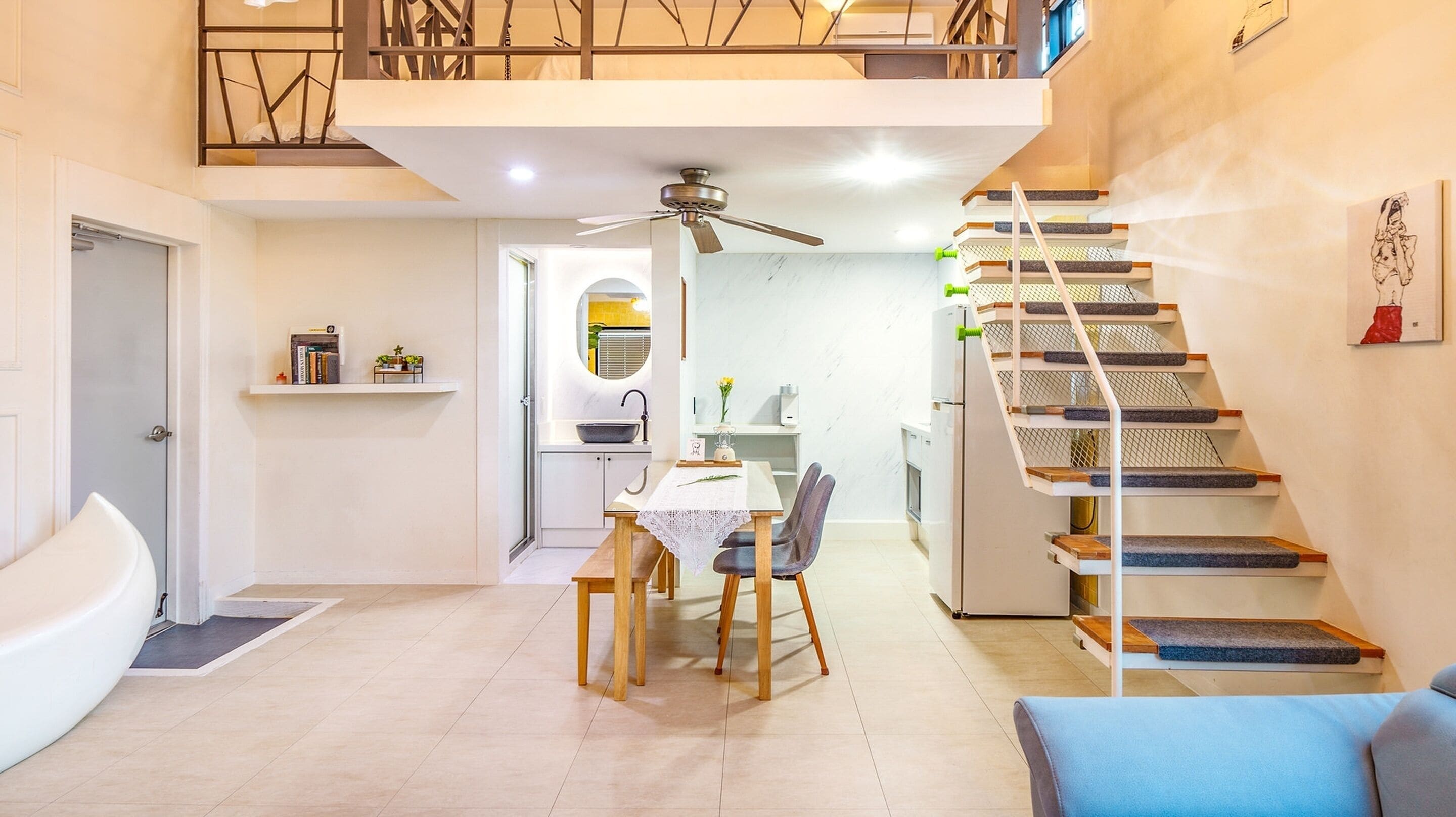 Un apartamento moderno con comedor, cocina y escalera.