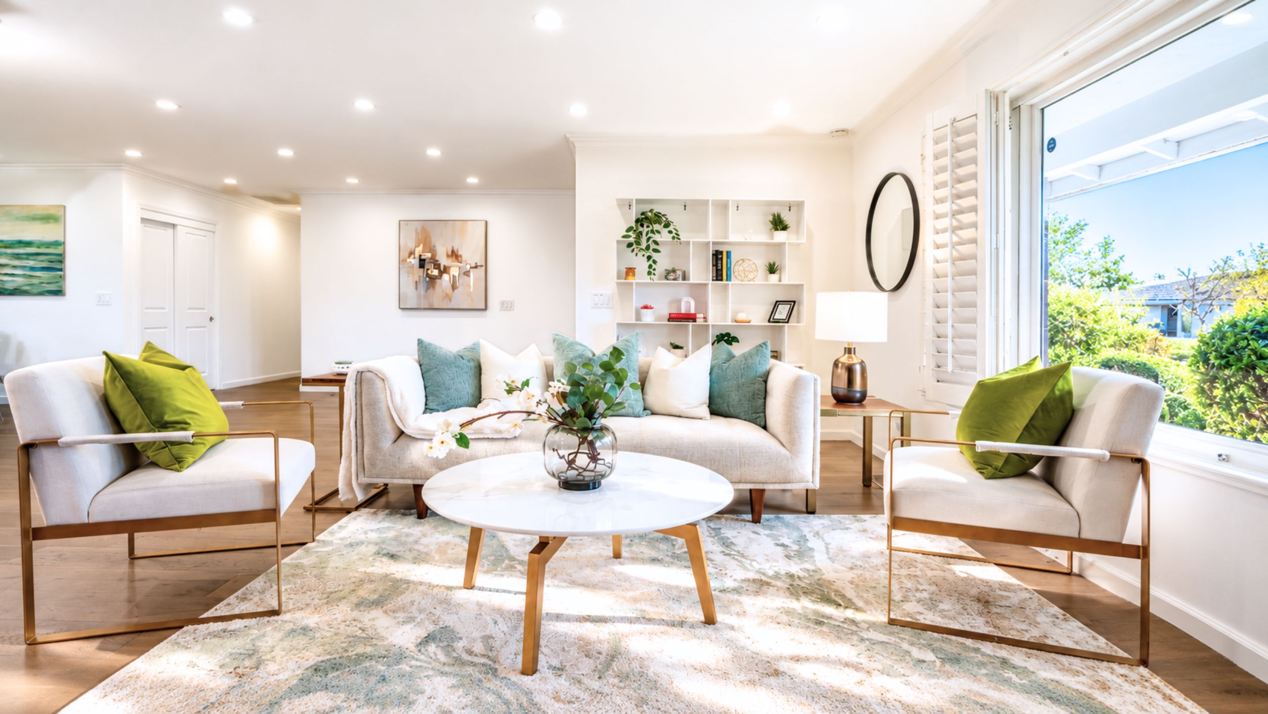 A modern living room with a round coffee table, two sofas, and a bookshelf.