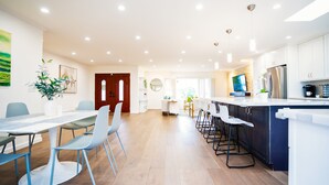 A modern kitchen with white cabinets, a large island, and bar stools.