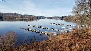 A calm lake with docks and boats, surrounded by hills and trees. - Country cottage (Linards)
