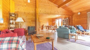 A cozy log cabin interior with a living room, dining area, and a kitchen. - Country cottage (Linards)