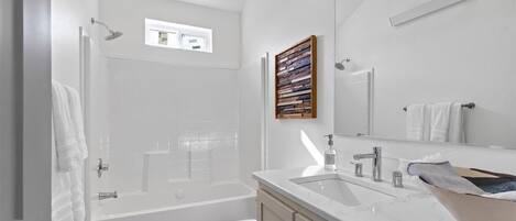 A modern bathroom with a bathtub, toilet, and sink.