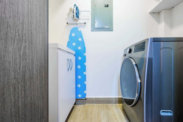 A laundry room with a washing machine, a dryer, and a blue wall with white stars.