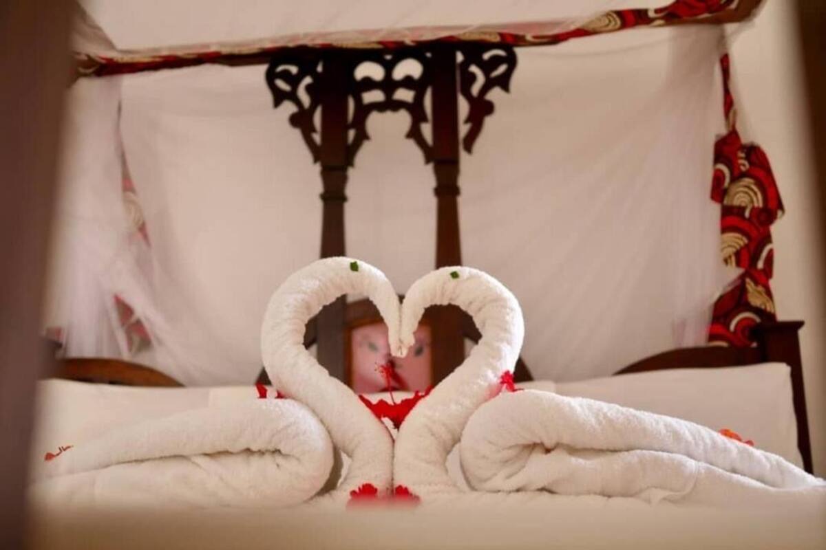 Una cama con dosel y un cabecero decorativo.