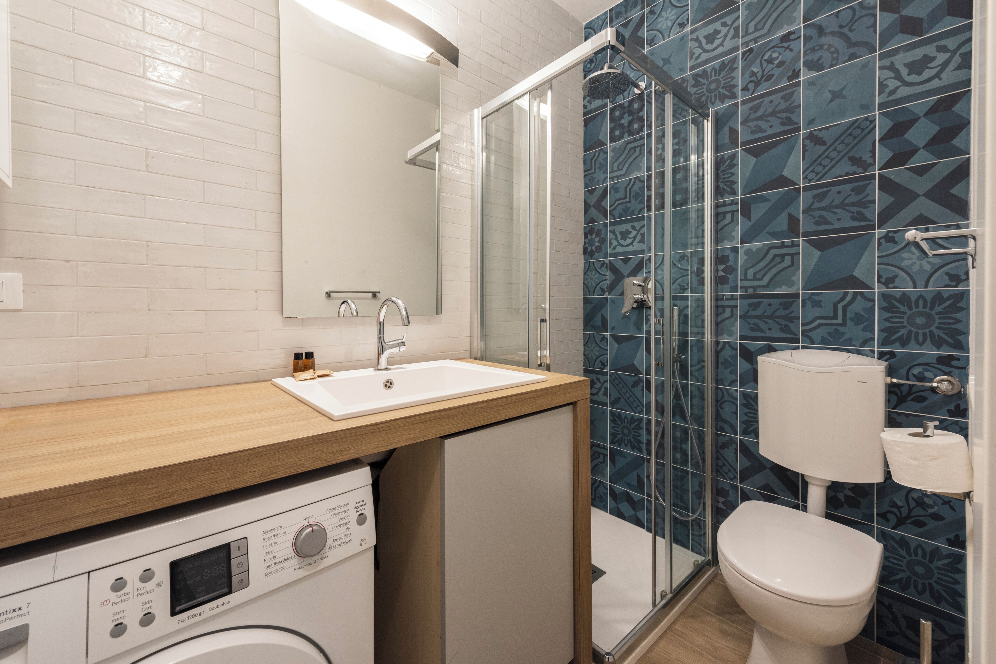 A modern bathroom with a shower, toilet, and sink.
