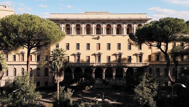 Un grand bâtiment historique doté de nombreuses arcades et d’une cour intérieure.