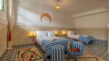 Two beds with striped bedding, a decorative wall hanging, and a patterned rug adorn this traditional room.