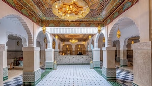 A spacious interior with a checkered floor, ornate ceiling, and symmetrical arches. - Palais Moulay Said & SPA (Marrakech)