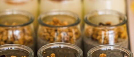 A row of glass jars containing chia pudding with granola on top.