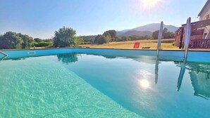 En klar swimmingpool med udsigt til bjerge i baggrunden.