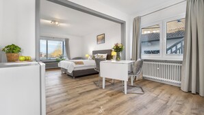 Une chambre d’hôtel moderne, équipée d’un lit, d’un bureau et offrant une vue sur la ville.