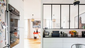 Eine moderne Küche mit Einbauofen, Kaffeemaschine und Obstschale.