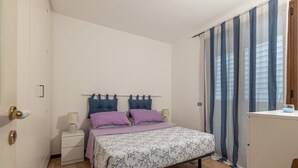 A bedroom with a bed, nightstands, a dresser, and curtains. - Casa Azzurra Seaview Addaura by Wonderful Italy (Palermo)
