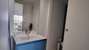 Un baño con lavamanos blanco, un mueble de almacenamiento azul y un inodoro.