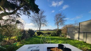 Una mesa con un menú, croissants y una taza en un jardín.