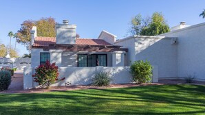 A modern house with a white exterior, a red-tiled roof, and a well-maintained lawn. - Cozy House, Pool, Spa, Tennis & Pickleball Courts (Tempe)