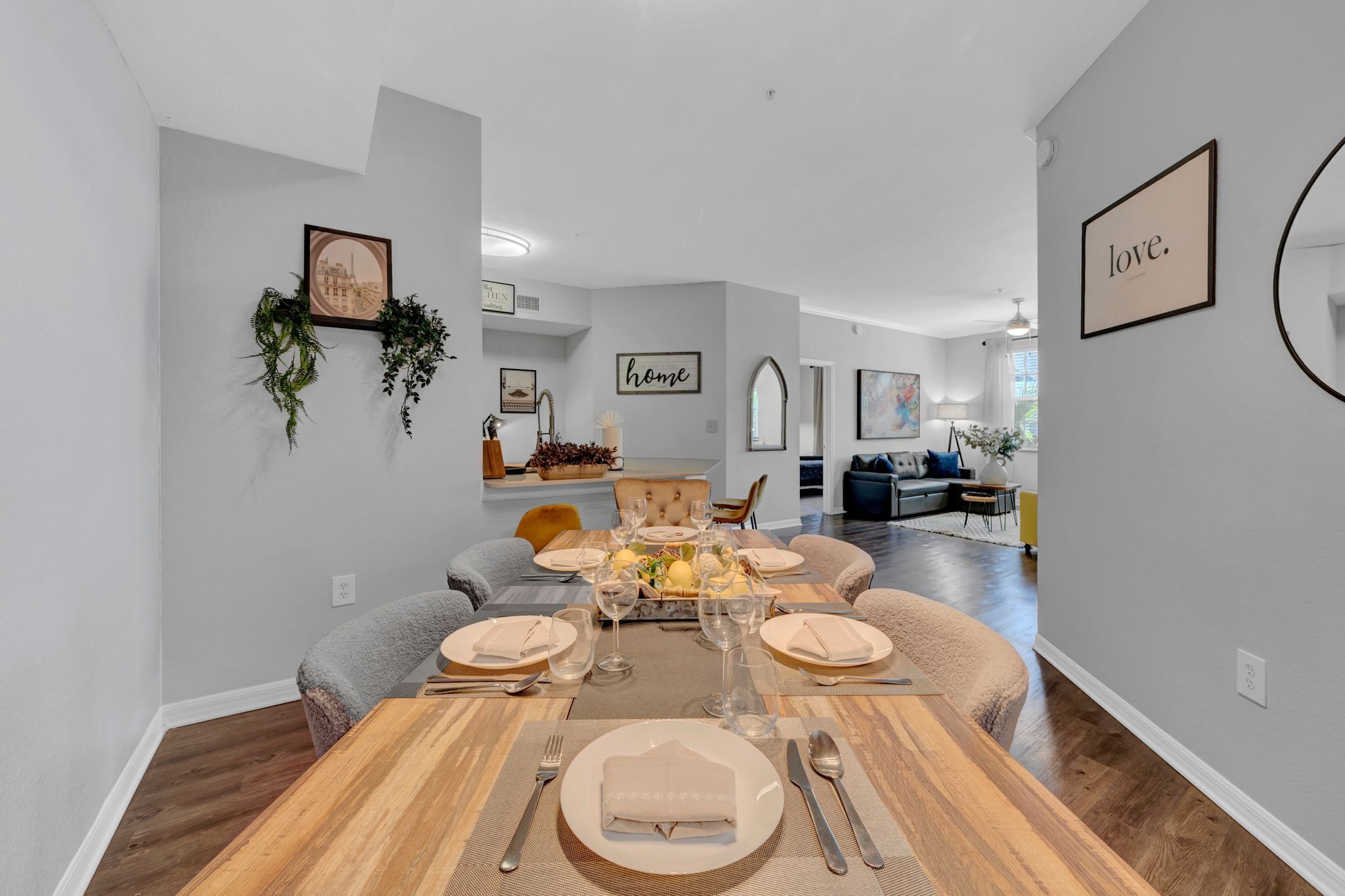Un coin repas avec une table en bois dressée pour six personnes, entourée de chaises rembourrées.