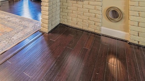 A room with a brick wall, a ceiling fan, and a large window. - Midtown Family Getaway w/ Game Room & Backyard (Columbus)