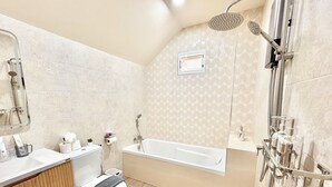 Un baño moderno con bañera, ducha, inodoro y tocador.