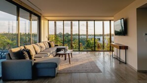 Una sala de estar moderna con un sofá grande, una mesita de centro y un televisor sobre un mueble.