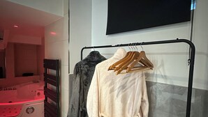 A modern bathroom with a black bathtub, a towel rack with robes, and a large mirror. - # Le 7 # Nuitée torride, balnéo, tantra Mulhouse centre (Mulhouse)