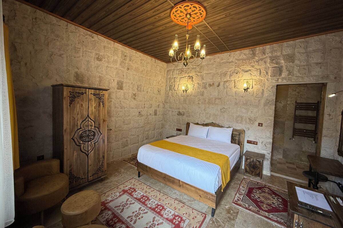 Une chambre rustique avec un lit en bois, une grande armoire et un lustre.