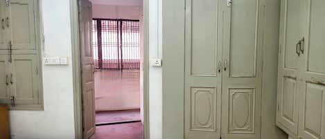 A room with a bed, a wardrobe, and a door leading to a balcony.