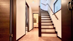 Ein Flur mit einer Treppe, die zu einer zweiten Etage führt.