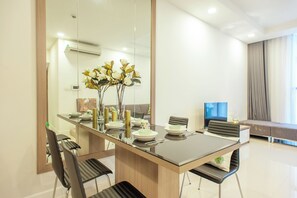 Un comedor moderno con una mesa de vidrio, sillas y un jarrón de flores.