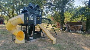 A playground with a slide and a climbing structure. - Rural 2 bedroom fully equiped Chalet (1 of 2) by lake near Chaillac sleeps max 6 (Chaillac)