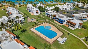 A resort with a large swimming pool, multiple buildings, and a beach view. - Playa Collect | Beachfront Haven w. Pool (Río Grande)