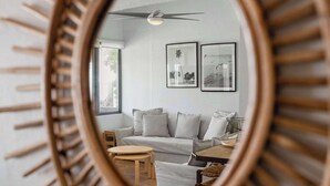 A room with a ceiling fan, a sofa, a small table, and two framed pictures on the wall. - Playa Collect | Beachfront Haven w. Pool (Río Grande)