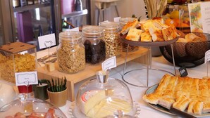 Een buffet met verschillende soorten eten, waaronder vleeswaren, kazen en brood.