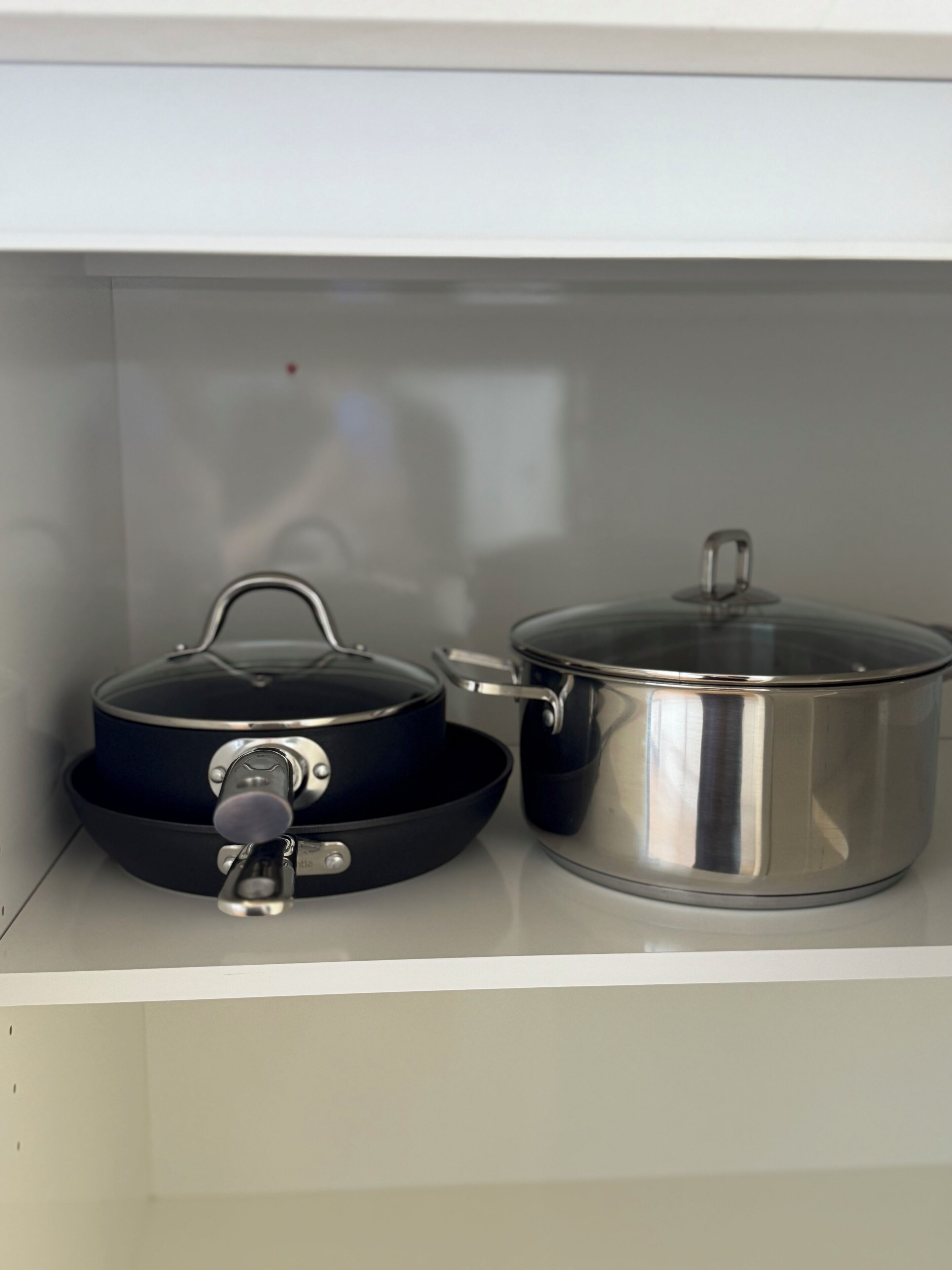 Uma prateleira na cozinha com duas panelas, uma com tampa e outra sem.