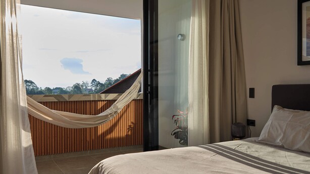 A bedroom with a bed, a view of the outdoors, and a wooden fence. - Villa Milá A3- Luxury sunset view - Close to everything (Salento)