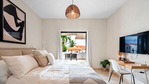 A bedroom with a bed, a desk, a TV, and a view of the outside. - Blue Villa Retreat (Río Grande)