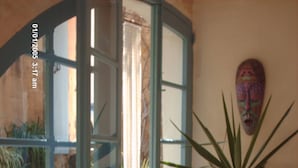 A room with a large window, a potted plant, and a door leading to another room. - Farmhouse With Pool and Valley Views (Munxar)