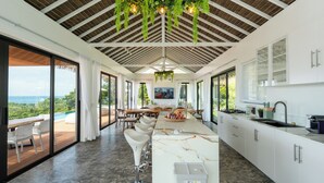 Una cocina moderna con encimera de mármol, armarios blancos y una isla grande.