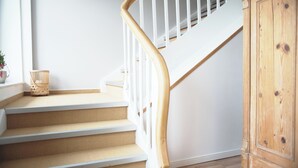 A staircase with wooden steps and white railings, leading to a wooden door. - Modern, spacious top-floor apartment with panoramic views of the Elbe (Hollern-Twielenfleth)