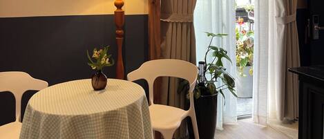 Un comedor con una mesa dispuesta para dos, una lámpara y un cuadro en la pared.