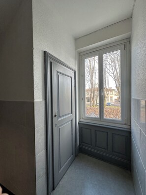 Una esquina de una habitación con una puerta y una ventana.