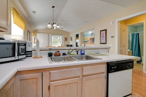 A compact kitchen with a microwave, sink, and dishwasher.