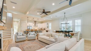A spacious living room with a large sofa set, a dining area, and a kitchen. - Walk to Gulf: Modern Retreat in Santa Rosa Beach! (Santa Rosa Beach)