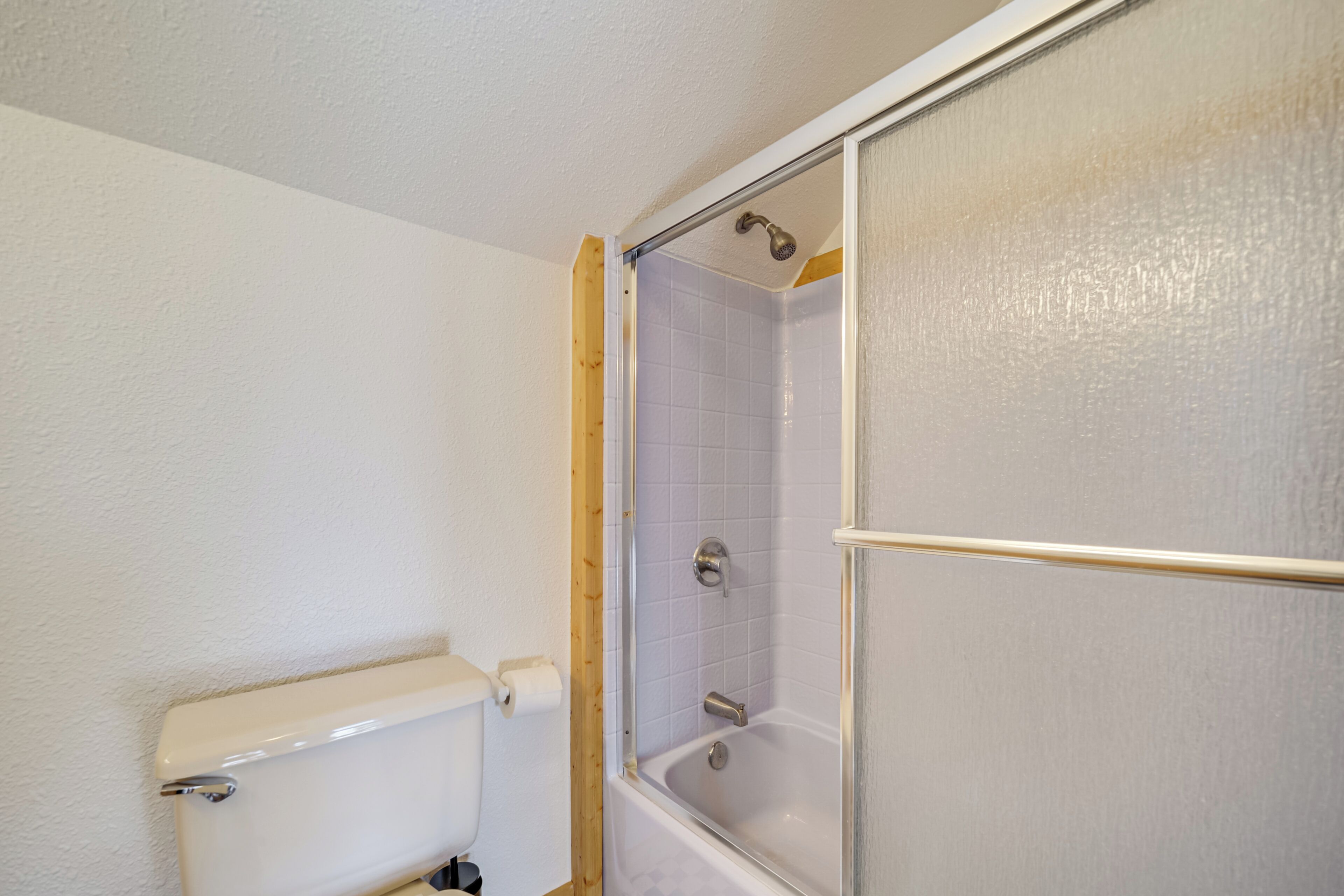 A bathroom with a toilet, a shower enclosure, and a bathtub.