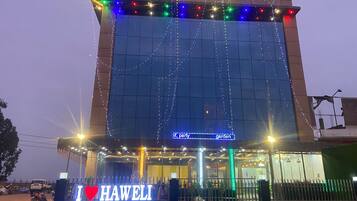 A building with a sign reading "HAWELI" and a neon sign below stating "party garden".