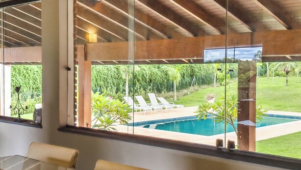 Un interior modern amb una finestra gran que fa a un jardí i una piscina.
