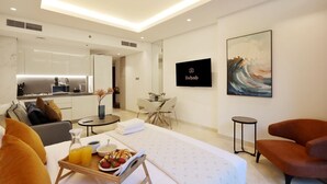 A modern hotel room with a bed, a dining area, a kitchen, and a living space. - Modern Studio Near Dubai Mall, Walk to Dubai Canal (Dubai)